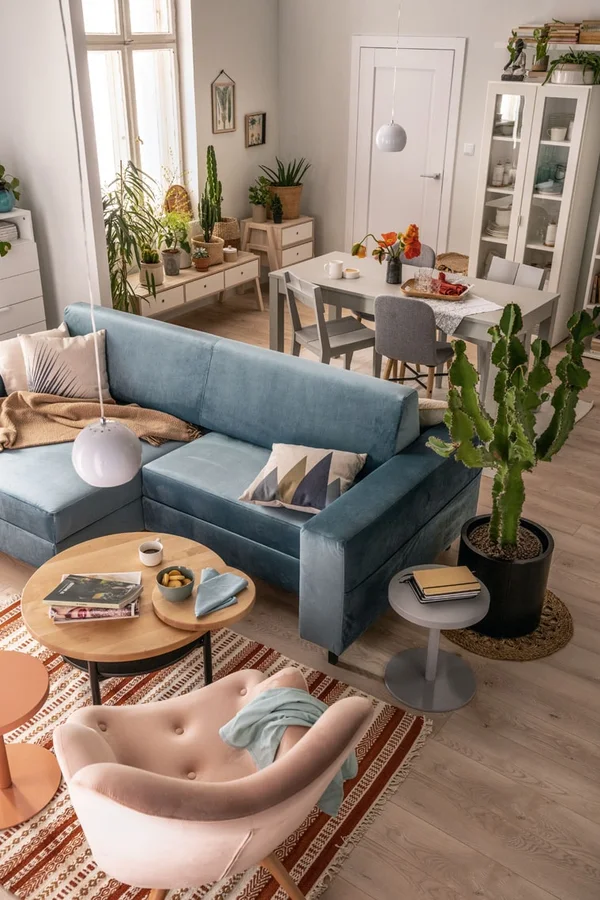 Niebieska sofa dwustronna w salonie z jadalnią
